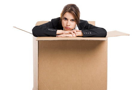 Stressed business woman appear inside a big card box, isolated over white background の写真素材