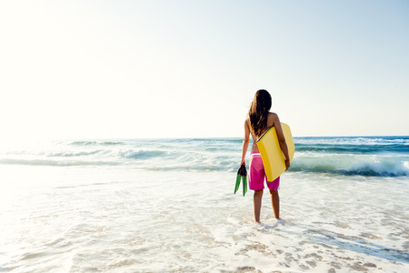 A beautiful girl at the beach with her bodyboardの写真素材