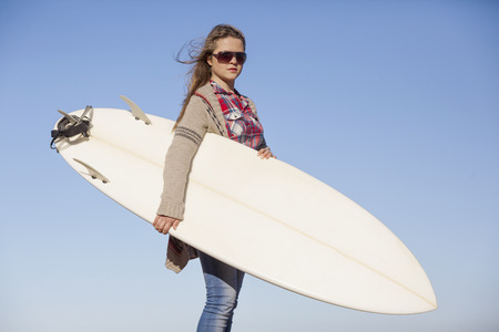 Tenage girl in the beach with her surfboardの写真素材