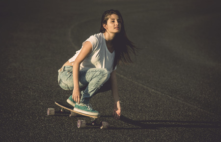 Young woman making downhill with a skateboardの写真素材