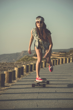 Young woman down the street with a skateboardの写真素材