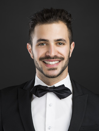 Portrait of a beautiful latin man smiling wearing a tuxedoの写真素材