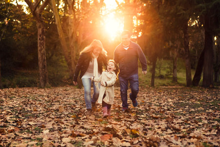 Outdoor portrait of a happy family enjoying the fall season