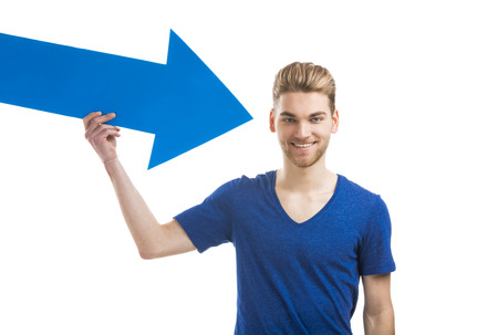 Good looking young man holding a blue arrow, isolated on a white backgroundの写真素材