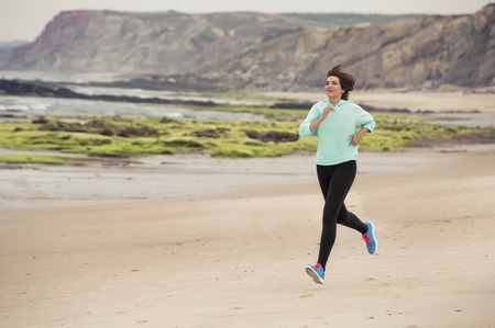Beautiful and healthy woman running on the beach