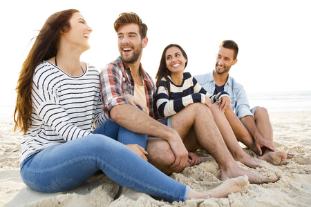 Multicultural group of friends at the beach having funの写真素材