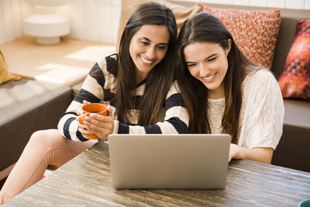 Female friends studying at the local coffee shopの写真素材