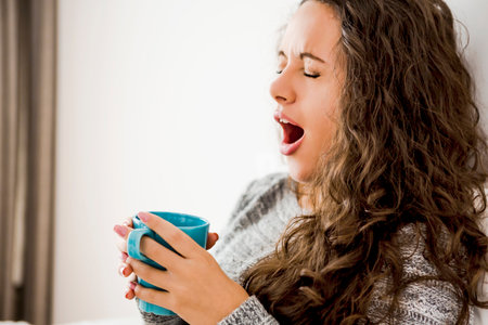 Beautiful woman on bed drinking a coffee