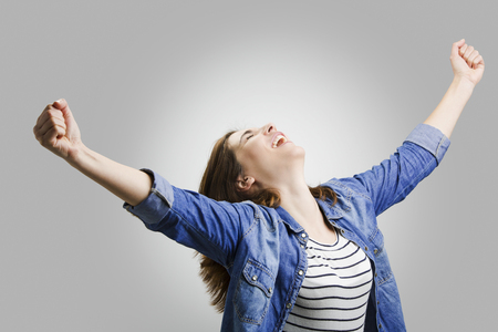Studio portrait of a happy woman with arms raisedの写真素材