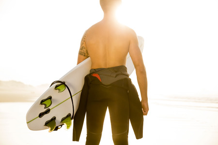 A surfer with his surfboard at the beach