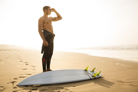 A surfer with his surfboard looking to the waves
