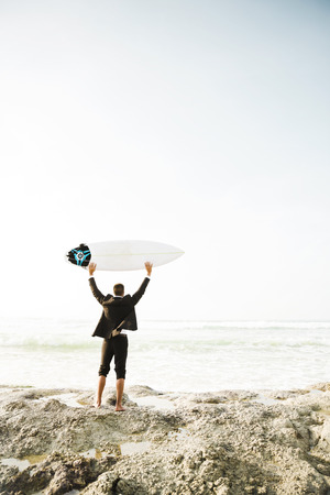 A Businessman holding is surfboard after a long day of workの写真素材