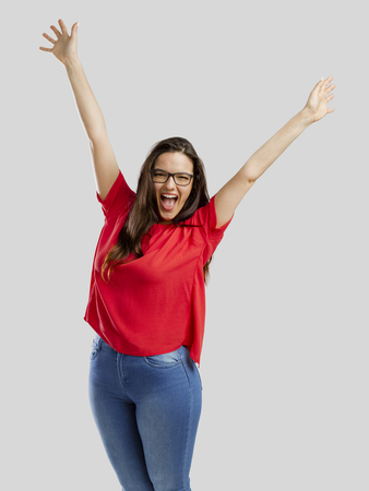 Happy woman with arms up, isolated over white backgroundの写真素材