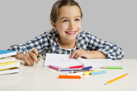 Little girl at school making drawings and painting