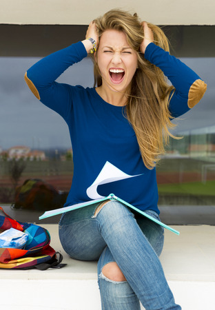 Beautiful teenage student with a stressed expression worried with somethingの写真素材