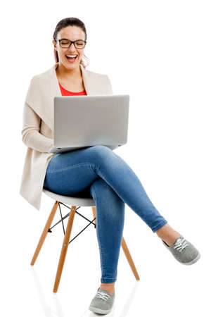 Beautiful and happy woman working with a laptop, isolated over white backgroundの写真素材