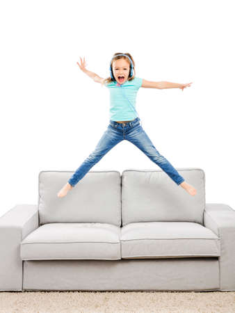 Cute blonde girl jumping and listen musicの写真素材