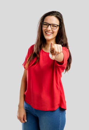 Happy woman smiling and pointing to the cameraの写真素材