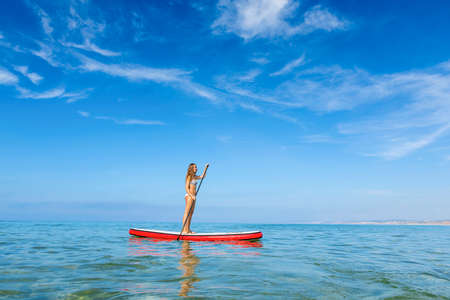 A beautiful woman practicing paddle on a beautiful sunny dayの写真素材