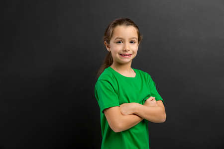 Smart little girl smiling in front of a blackboardの写真素材