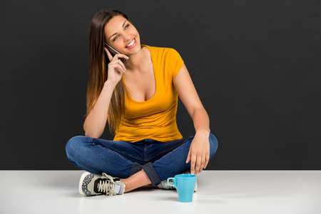 Beautiful woman sitting in the floor talking at phone