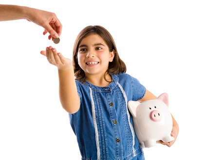 Young girl start her savings on a piggybankの写真素材