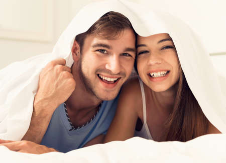 Young couple playing under the sheetsの写真素材