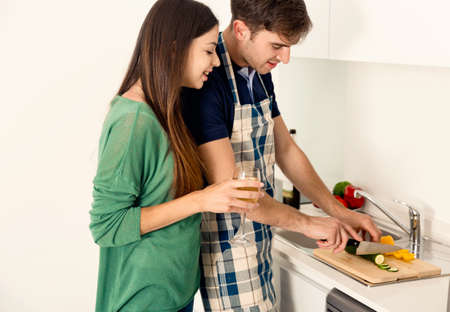 Young couple on the kitchen cookingの写真素材