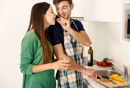 Young couple on the kitchen cookingの写真素材