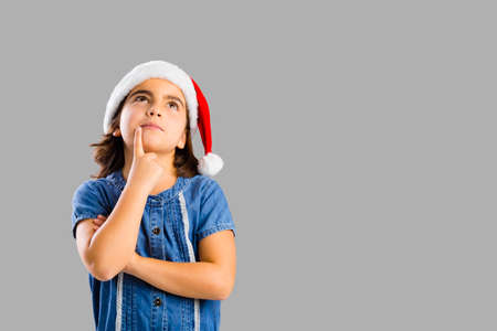 Studio portrait of a young girl thinking about Christmasの写真素材