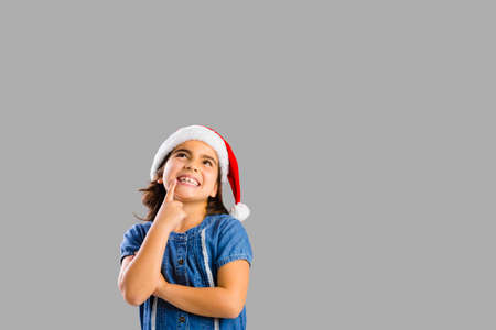 Studio portrait of a young girl thinking about Christmasの写真素材