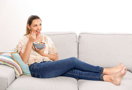 Beautiful happy woman at home eating a healthy bowlの写真素材