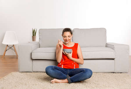 Beautiful happy woman at home eating a healthy bowl