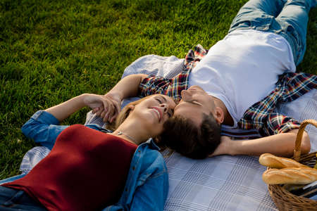 Happy young couple in the park relaxing after the picnicの写真素材