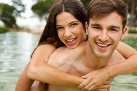 Portrait of a young couple embraced inside the poolの写真素材
