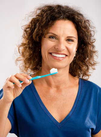 Beautiful mature woman brushing her teeths