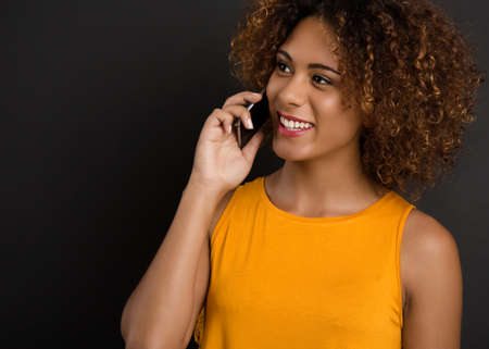 Beautiful African American woman making a phone call and laughingの写真素材