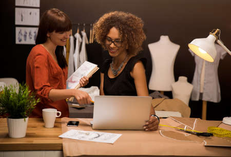 Two young entrepreneur women, and fashion designer working on her atelierの写真素材