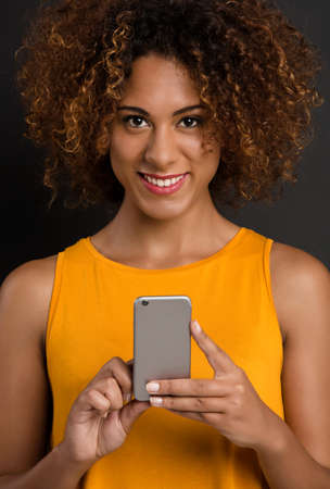Beautiful African American woman texting a sms