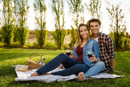 Shot of a beautiful couple on the park having fun together while making a picnicの写真素材
