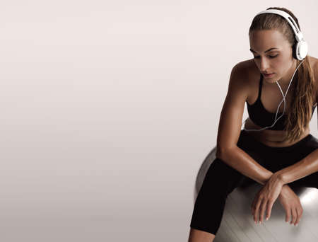Shot of a beautiful young woman sitting on swiss ball after the trainの写真素材