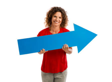Happy mature woman holding a blue arrow