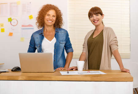 Two happy businesswoman working together in an officeの写真素材