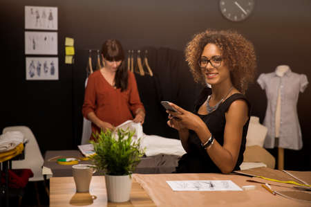 A young fashion designer on her atelier making a phone call
