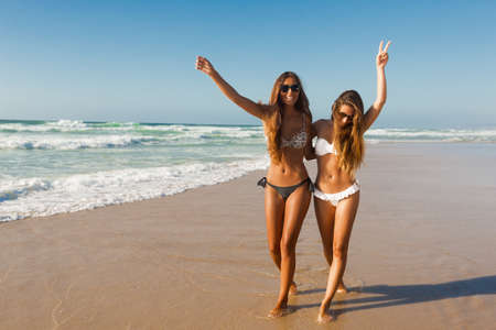 Beautiful girls walking and having fun on the beachの写真素材