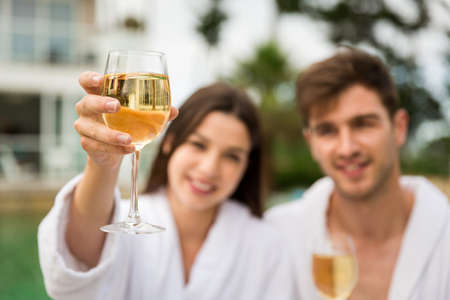 Young couple  in a luxury hotel tasting a glass of white wineの写真素材