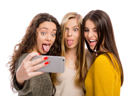 Teen girls with smartphone taking selfieの写真素材