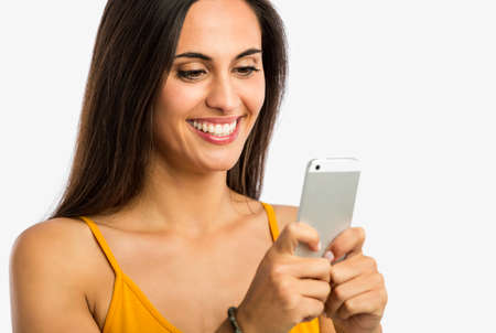 Beautiful and happy young woman sending a text message