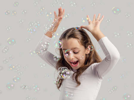 Cute little girl playing with soap bubblesの写真素材
