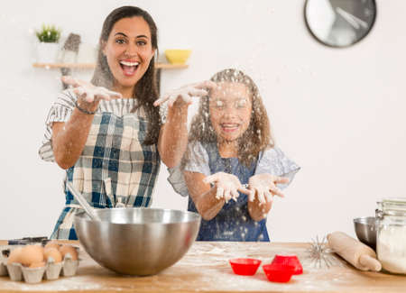 Shot of a mother and daughter having fun in the kitchen and learning to make a cakeの写真素材